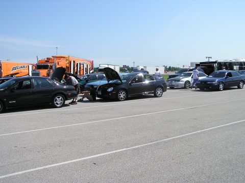 1993 Ford Taurus - Cars gathered at an event, with several hoods open for inspection or repair.