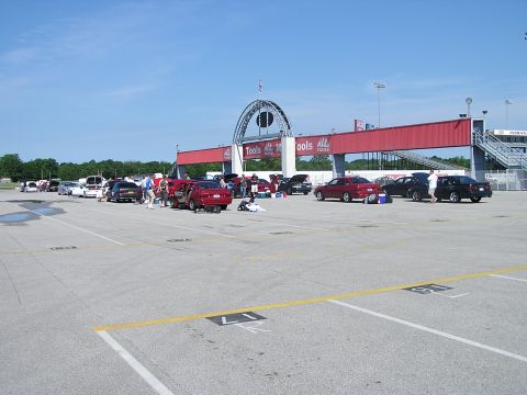 1993 Ford Taurus - A sunny day at the raceway with many cars gathered in the parking area.