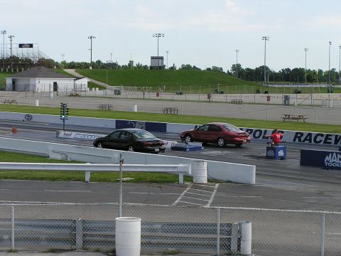 1993 Ford Taurus - Two sedans are seen racing on a drag strip, with Indianapolis Raceway signage visible in the background.