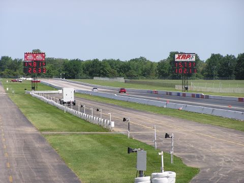 1993 Ford Taurus - Drag strip scene with digital scoreboards displaying race times and speeds. Two cars are on the track.