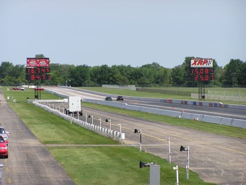 1993 Ford Taurus - A drag racing scene with digital timers showing elapsed times and speeds under a clear sky.