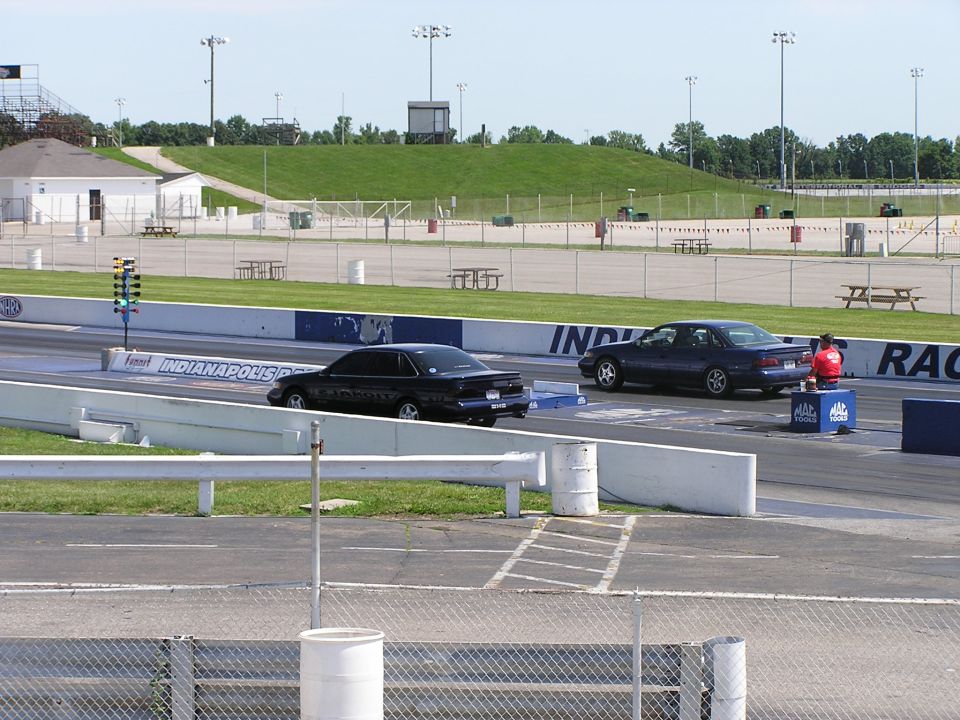 Black 1993 Ford Taurus rear view on drag strip