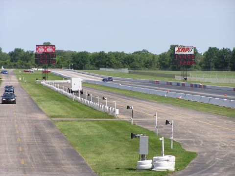 1993 Ford Taurus - Drag strip scene with scoreboards displaying race times and multiple vehicles on the track.
