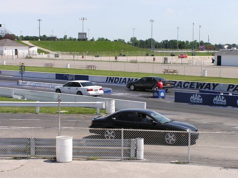 1993 Ford Taurus - Cars are lined up on the drag strip at Indianapolis Raceway Park, with a person in red standing by one of the vehicles.