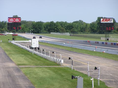 1993 Ford Taurus - A drag race is underway with two cars on the track and digital timers displaying their progress.