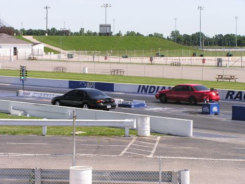 1993 Ford Taurus - Two sedans are lined up on a drag strip, ready for a race.