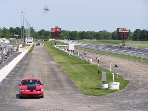 1993 Ford Taurus - Red 1993 Ford Taurus on drag strip, with racing numbers and digital timers visible.