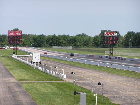 1993 Ford Taurus - Drag strip scene with two cars competing and digital timing displays.