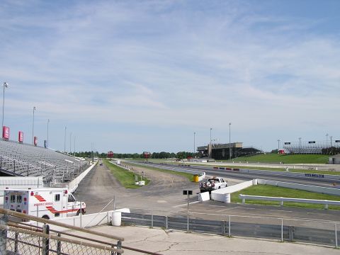 1993 Ford Taurus - An ambulance is visible at a drag strip, with grandstands and a clear sky overhead.