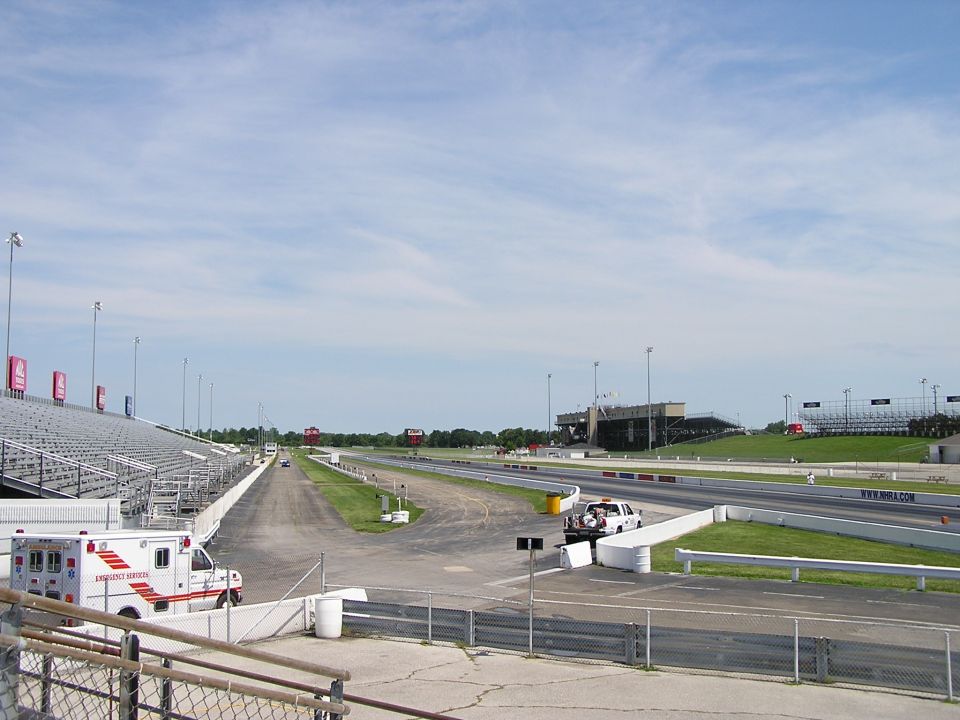 Ambulance parked at drag strip with grandstands