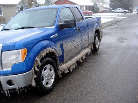 2008 Ford Crown Victoria - A blue Ford F-150 pickup truck is covered in ice from a recent storm.