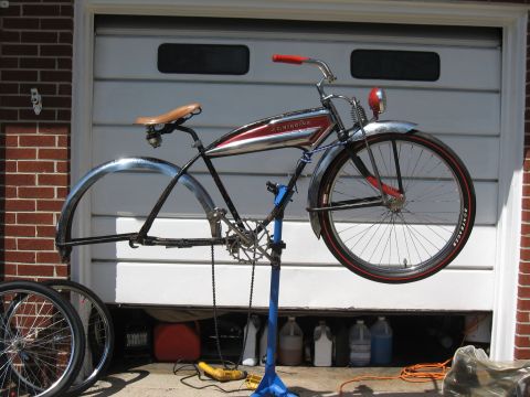 1994 Ford Bronco - A vintage bicycle with a red and chrome frame is mounted on a repair stand in front of a garage door.