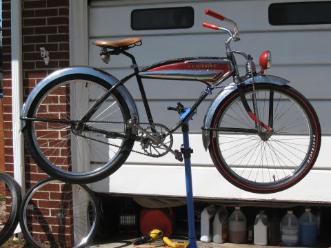 1994 Ford Bronco - A vintage J.C. Higgins bicycle is mounted on a repair stand in front of a garage door.
