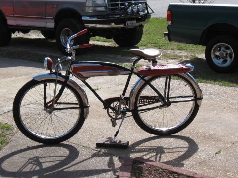 1994 Ford Bronco - A vintage bicycle with a distinctive red and chrome frame is displayed outdoors, with other vehicles partially visible.