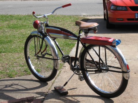1994 Ford Bronco - A vintage bicycle with red accents and chrome fenders is parked on a driveway next to an orange car.
