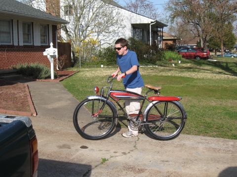 1994 Ford Bronco - A young man stands with a classic red and black bicycle on a suburban driveway.