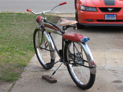 1994 Ford Bronco - A vintage bicycle is parked on a concrete driveway next to a red car.