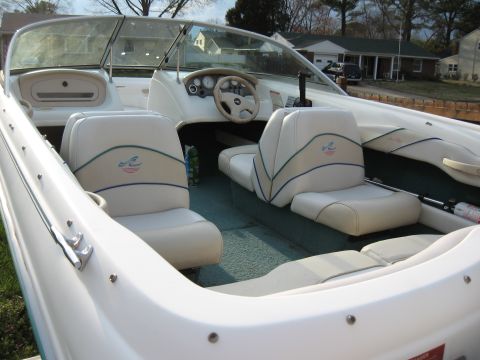 1994 Ford Bronco - The interior of a white boat features upholstered seats and a dashboard with gauges.