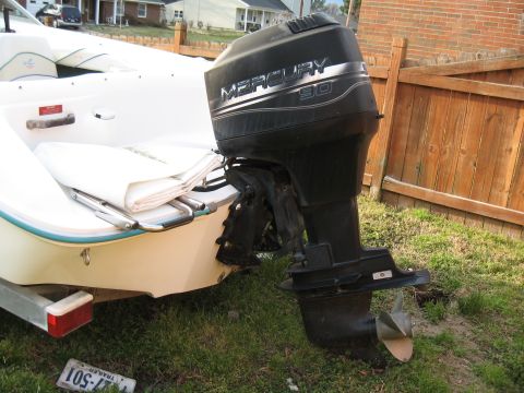 1994 Ford Bronco - A Mercury 90 outboard motor is attached to the stern of a white boat, with a trailer visible below.
