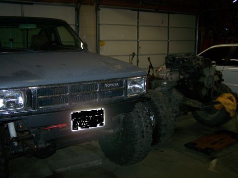 1988 Suzuki Samurai - Toyota truck in garage, engine removed, with another vehicle behind it.