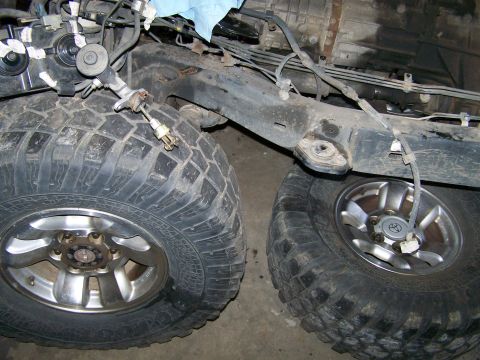 1988 Suzuki Samurai - Detail view of off-road tires and suspension components, likely part of a custom build or repair.