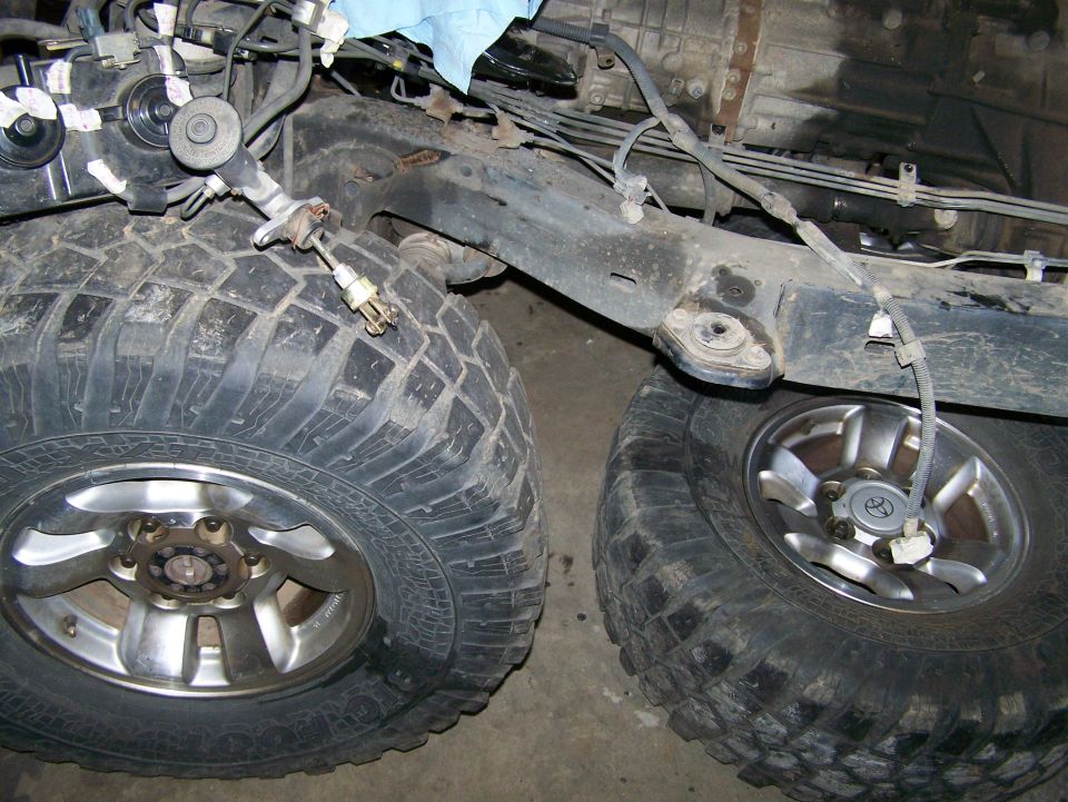 Close-up of large off-road tires and vehicle chassis components