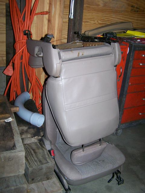 1988 Suzuki Samurai - A car seat is shown removed from a vehicle, with a toolbox and extension cord in the background.