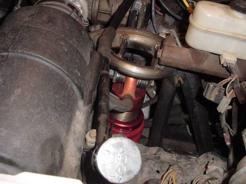 1987 Ford Bronco - Close-up view of a red coilover shock absorber and other engine components, including a K&N branded cap.