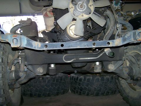 1988 Suzuki Samurai - The underside of a vehicle's engine and chassis is shown, with large tires supporting it.