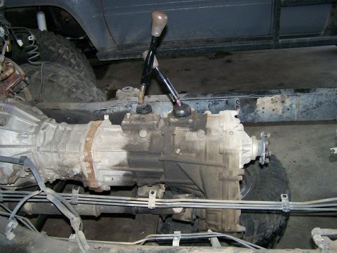1988 Suzuki Samurai - Close-up view of a transfer case and transmission assembly with dual shifters, likely part of a custom modification.