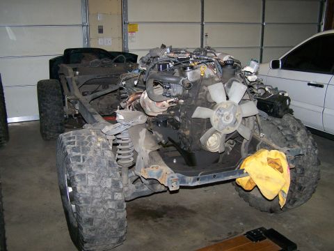1988 Suzuki Samurai - Chassis of a vehicle undergoing modification, with engine and suspension exposed.