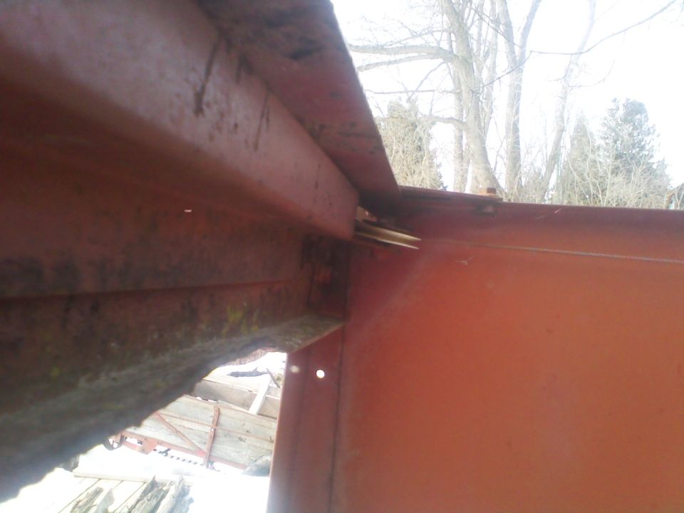 Close-up of rusted red metal frame with visible bolts and bracing