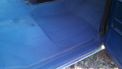 1979 Ford Bronco - The interior floor of a vehicle, painted blue, shows signs of wear and repair.