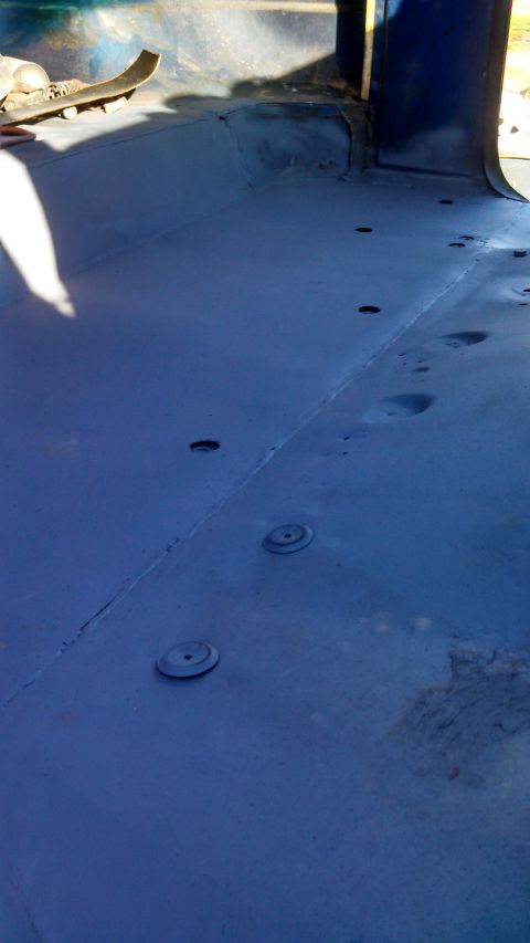 1979 Ford Bronco - The interior floor of a blue vehicle, showing rivets and a skateboard, with the "Supermotors.net" watermark visible.