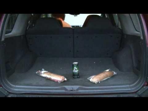 2006 Ford E350 - The rear cargo area of an SUV contains two wrapped sandwiches and a beverage can.