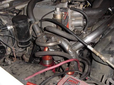 1987 Ford Bronco - Custom exhaust and engine components in an engine bay, an MSD ignition box.