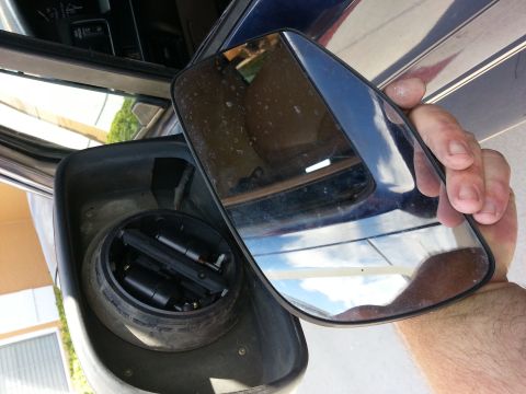 1994 Ford Bronco - A person holds a detached side mirror, revealing the internal mechanism and a view of the vehicle's interior.