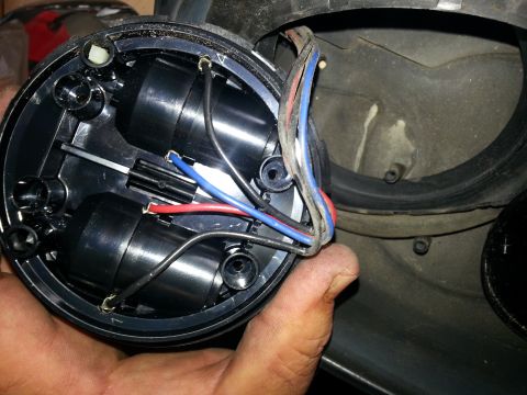 1994 Ford Bronco - Close-up of a vehicle headlight assembly, showing internal wiring and components.