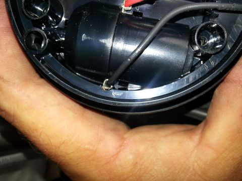 1994 Ford Bronco - A hand holds a black plastic component with electrical wires and a red connector, with a website logo in the corner.