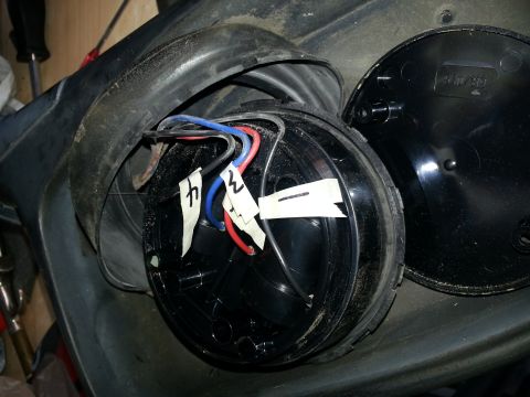1994 Ford Bronco - Close-up of a disassembled car mirror assembly with visible wiring and labels.
