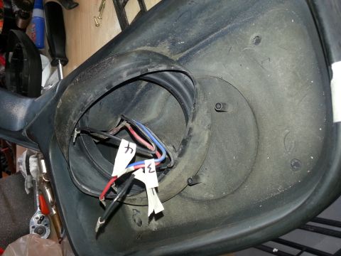 1994 Ford Bronco - Close-up of a disassembled vehicle mirror housing, showing internal wiring and mounting points.