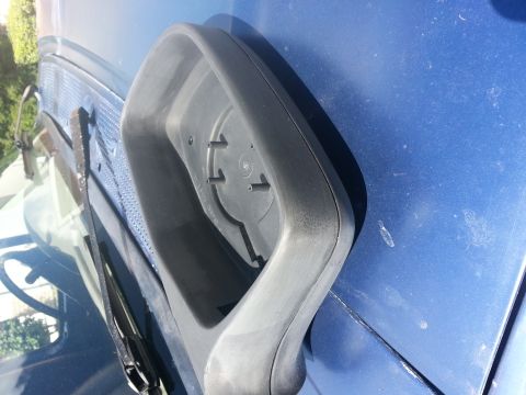 1994 Ford Bronco - The housing for a side mirror is shown detached from a blue vehicle.