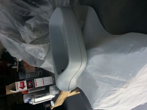 1994 Ford Bronco - A gray plastic car part is seen covered in protective sheeting, with spray cans and boxes in the background.