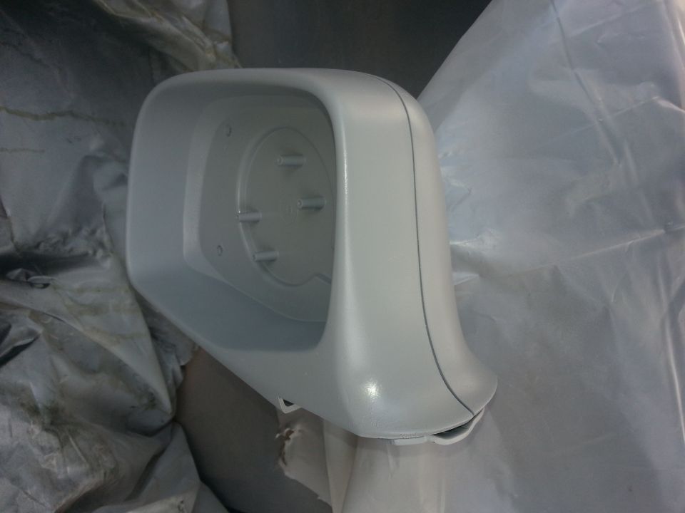 Unpainted car side mirror housing with mounting points visible inside