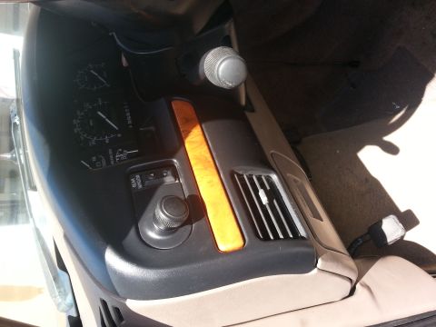 1994 Ford Bronco - Interior view of a 1994 Ford Bronco, highlighting the dashboard gauges, wood trim accents, and climate controls.