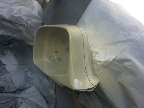 1994 Ford Bronco - A beige car side mirror housing is shown, partially covered by tarps, with mounting points visible inside.