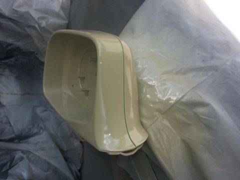 1994 Ford Bronco - A beige side mirror housing is shown resting on a tarp, likely during a painting or restoration process.
