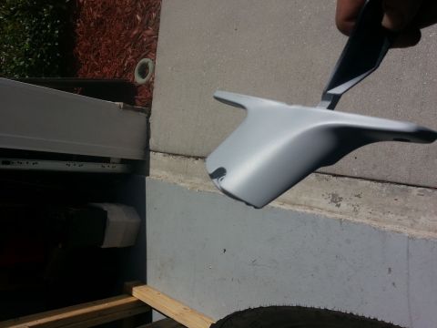 1994 Ford Bronco - A gray plastic automotive part is held up for inspection, possibly before or after hydrographic treatment.