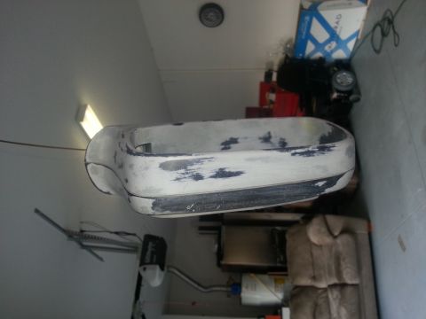 1994 Ford Bronco - A detached car bumper is shown in a garage setting, appearing to be prepped for painting.