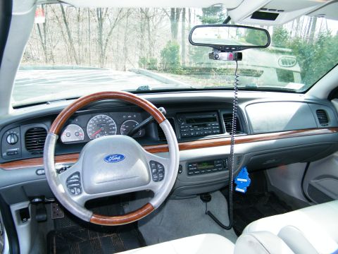 2004 Ford Crown Victoria - The interior of a 2004 Ford Crown Victoria, a wood-trimmed steering wheel and a clean dashboard.